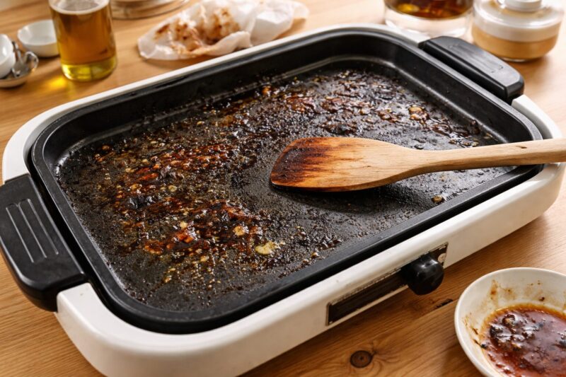 焦げや油汚れが付いたホットプレートのプレート表面
