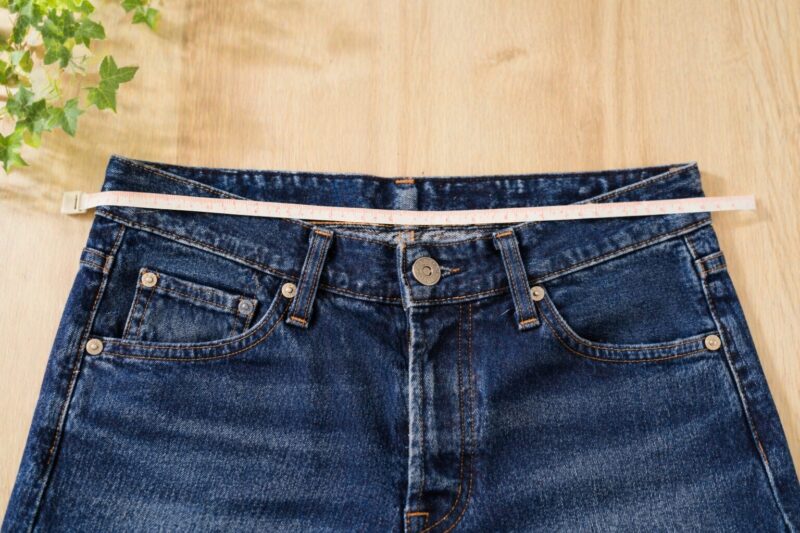 ズボンのウエストサイズをメジャーで測っているイメージ