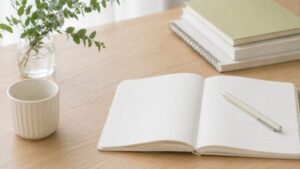 ノートにコメントを書き始めるイメージの手元写真