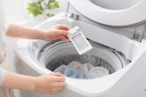 洗濯機のゴミ取りネットを取り外して破れや汚れを確認している様子