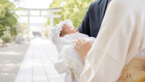 お宮参りで赤ちゃんを抱く家族の様子