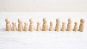 大所帯と大世帯の違いを表す大人数の木製人形