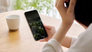 日にちが決まってない誘いの断り方に迷いスマホで返信を考える手元