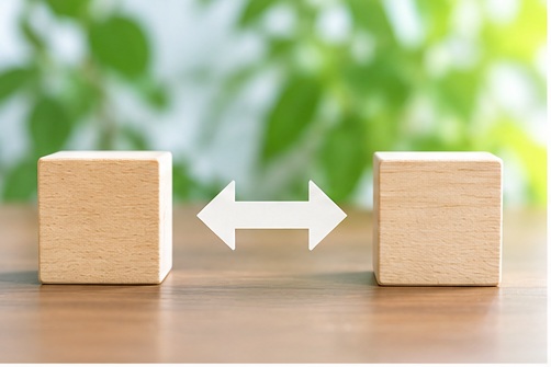 付随と付帯の違いを表す2つの木製ブロックと双方向矢印